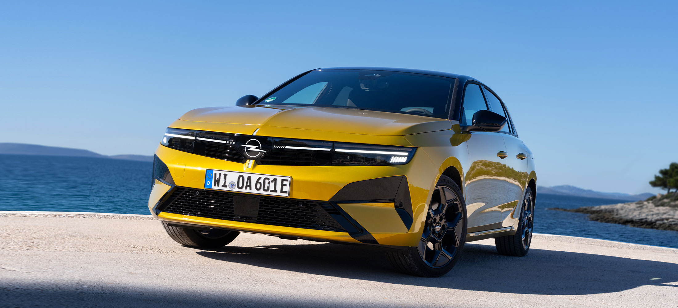 Neuer Opel Astra in Gelb vor einem Meer