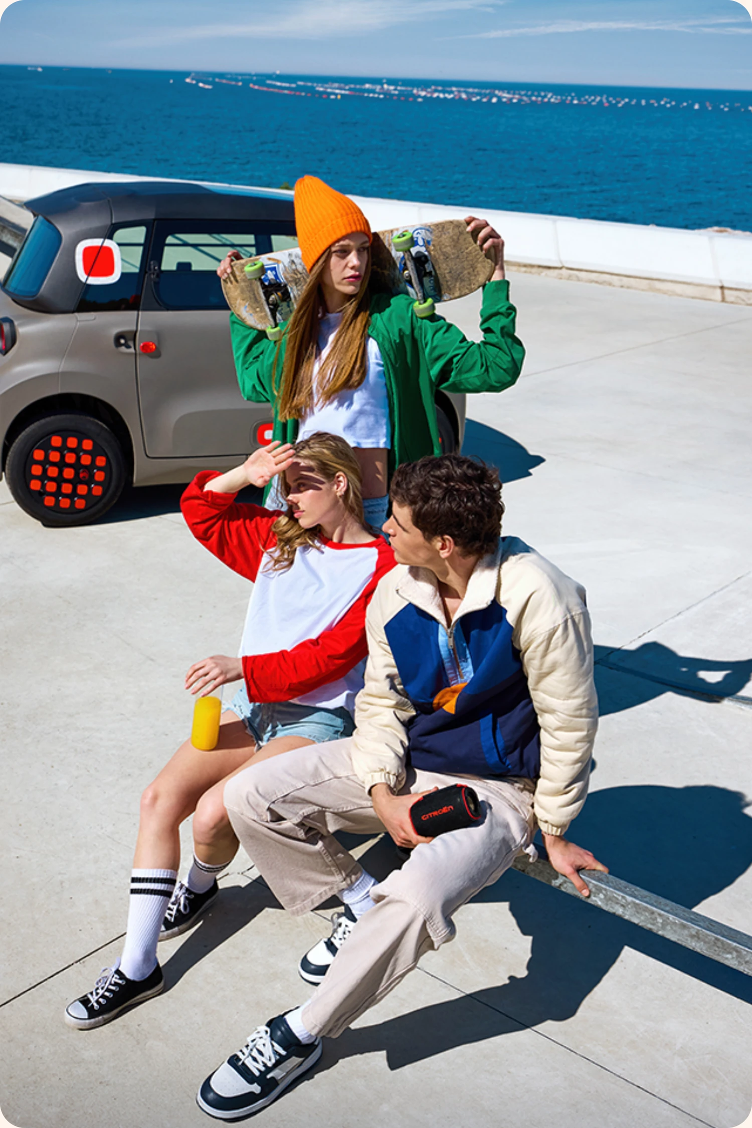 Citroen Ami im Hintergrund - im Vordergrund 3 junge Leute mit Skateboard