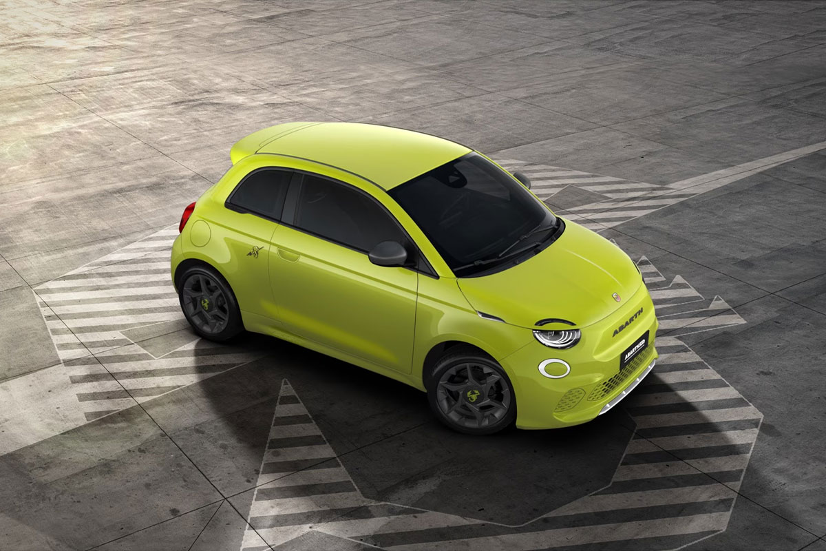 Abarth 500e in der Farbe Acid Green Uni steht auf einem Betonplatz. Kompakter Elektro-Stadtflitzer mit sportlichem Design und markanten Linien.