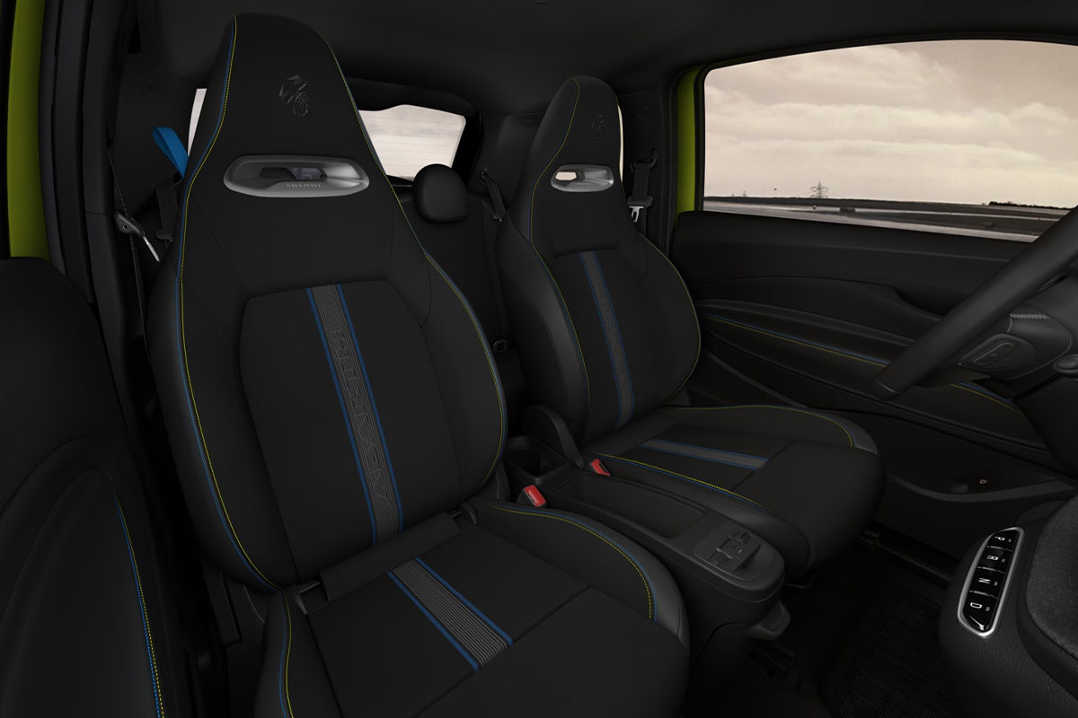 Vordersitze und Rückbank des Abarth 500e in schwarzem Sportdesign mit blauen Ziernähten.