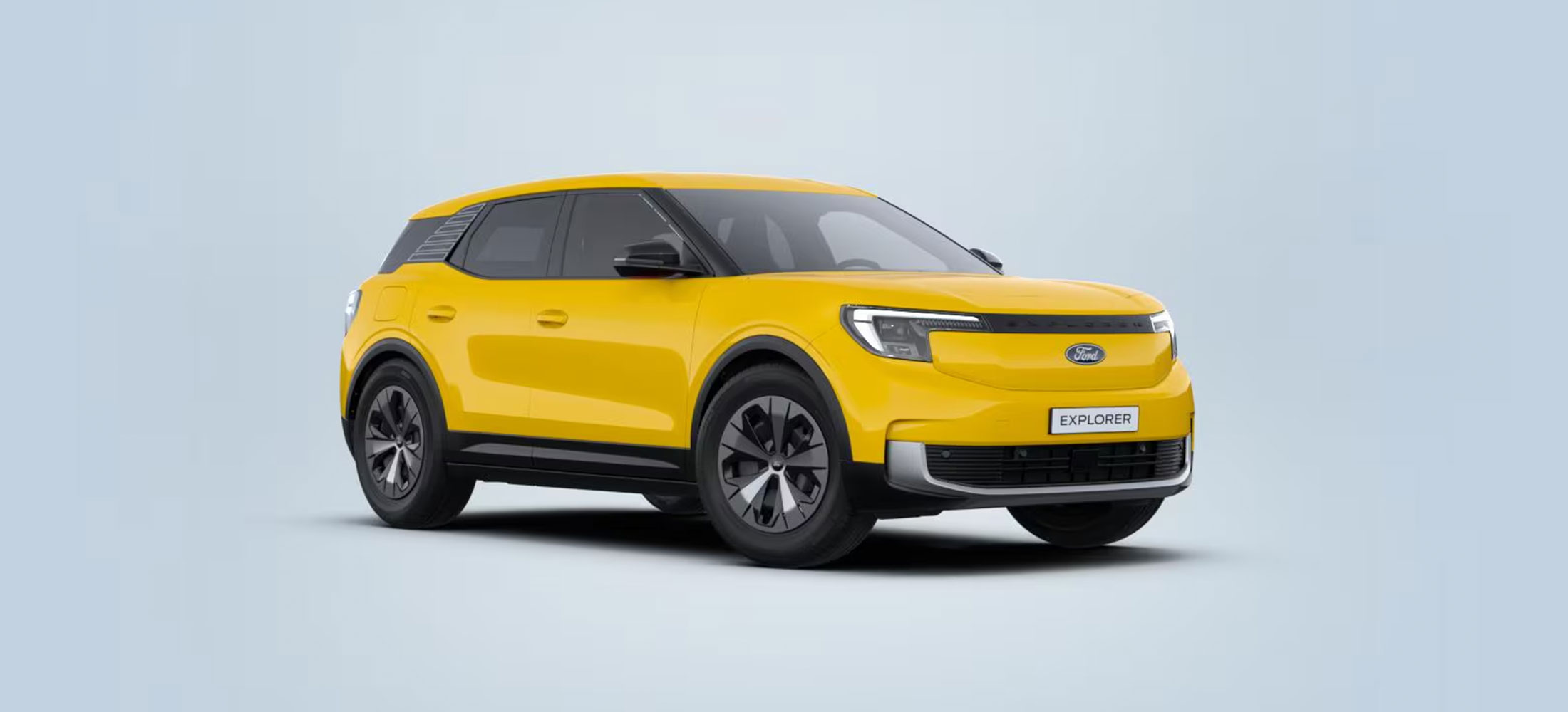 Gelber Ford Explorer in schräger Frontansicht vor hellem Hintergrund.