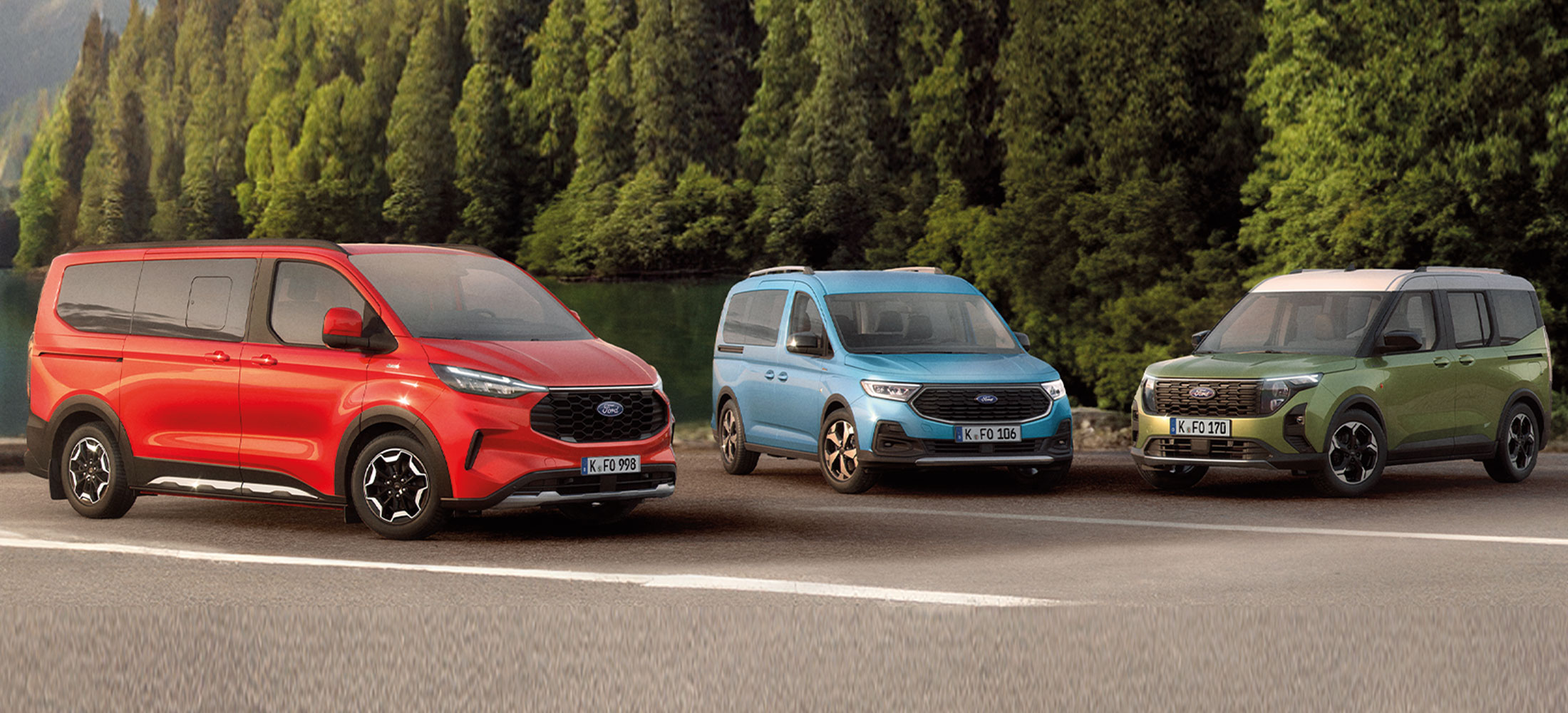 Drei Ford Hochdachkombis nebeneinander: links ein roter Ford Tourneo Custom, in der Mitte ein blauer Ford Tourneo Connect und rechts ein grüner Ford Tourneo Courier, vor einer grünen Waldlandschaft.