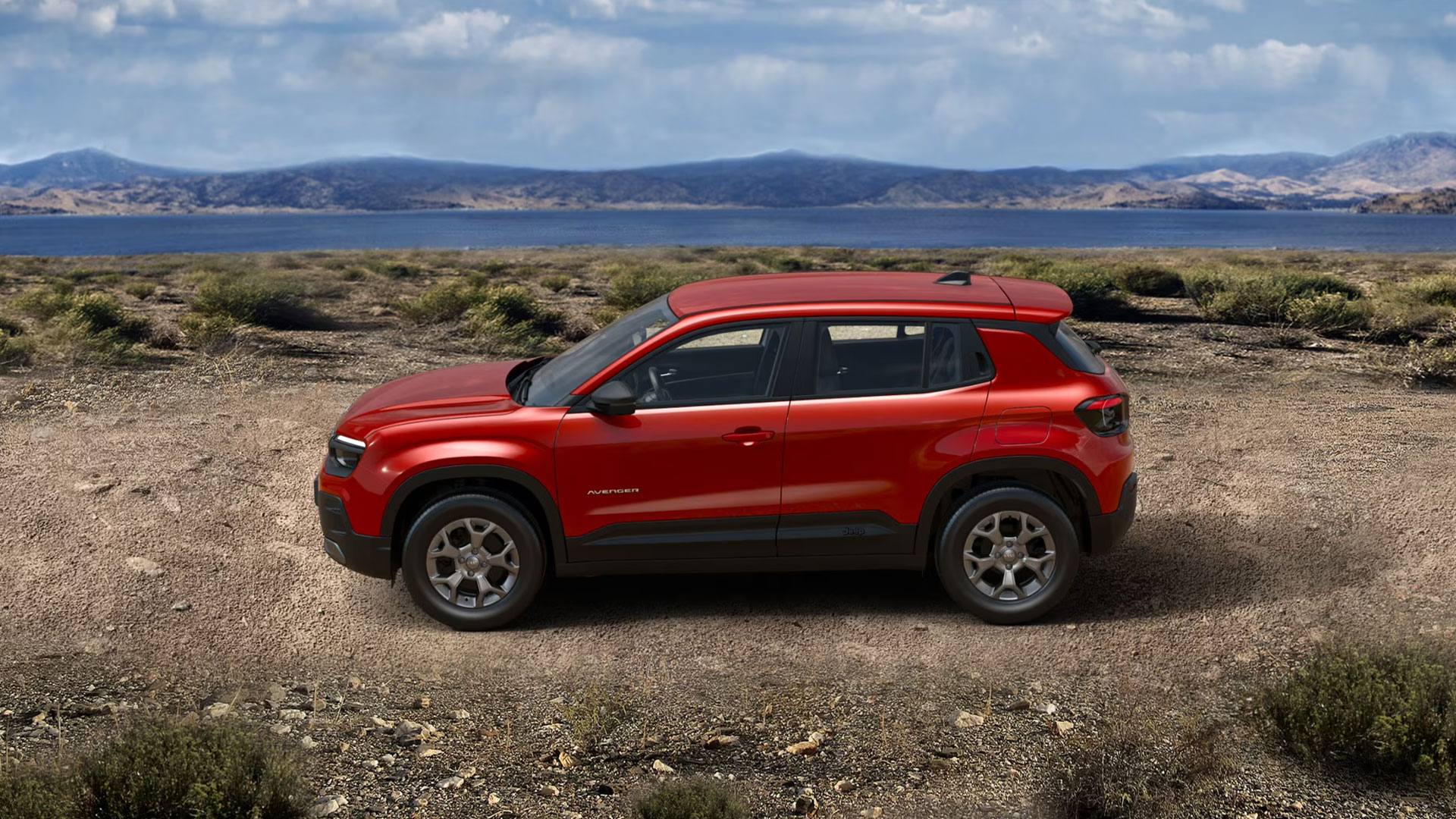 Jeep Avenger Longitude e-Hybrid in Ruby Red von der Seite. Im Hintergrund eine Landschaft