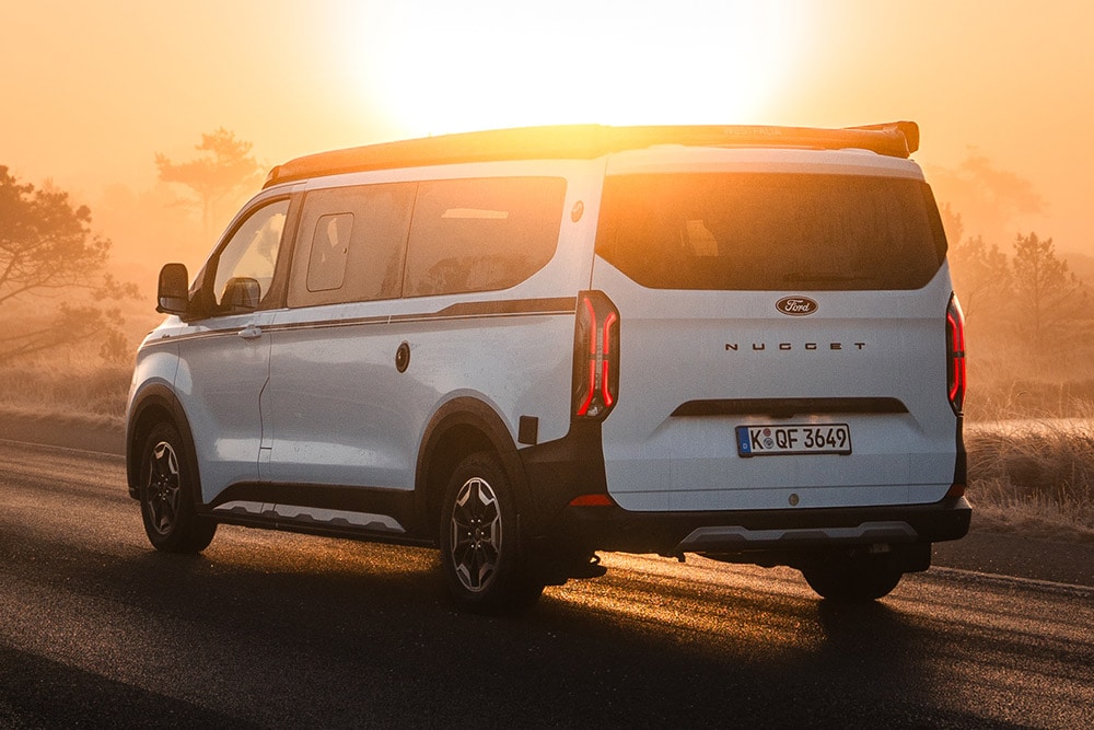 Ford Campervan in schräger Heckansicht bei Sonnenuntergang.