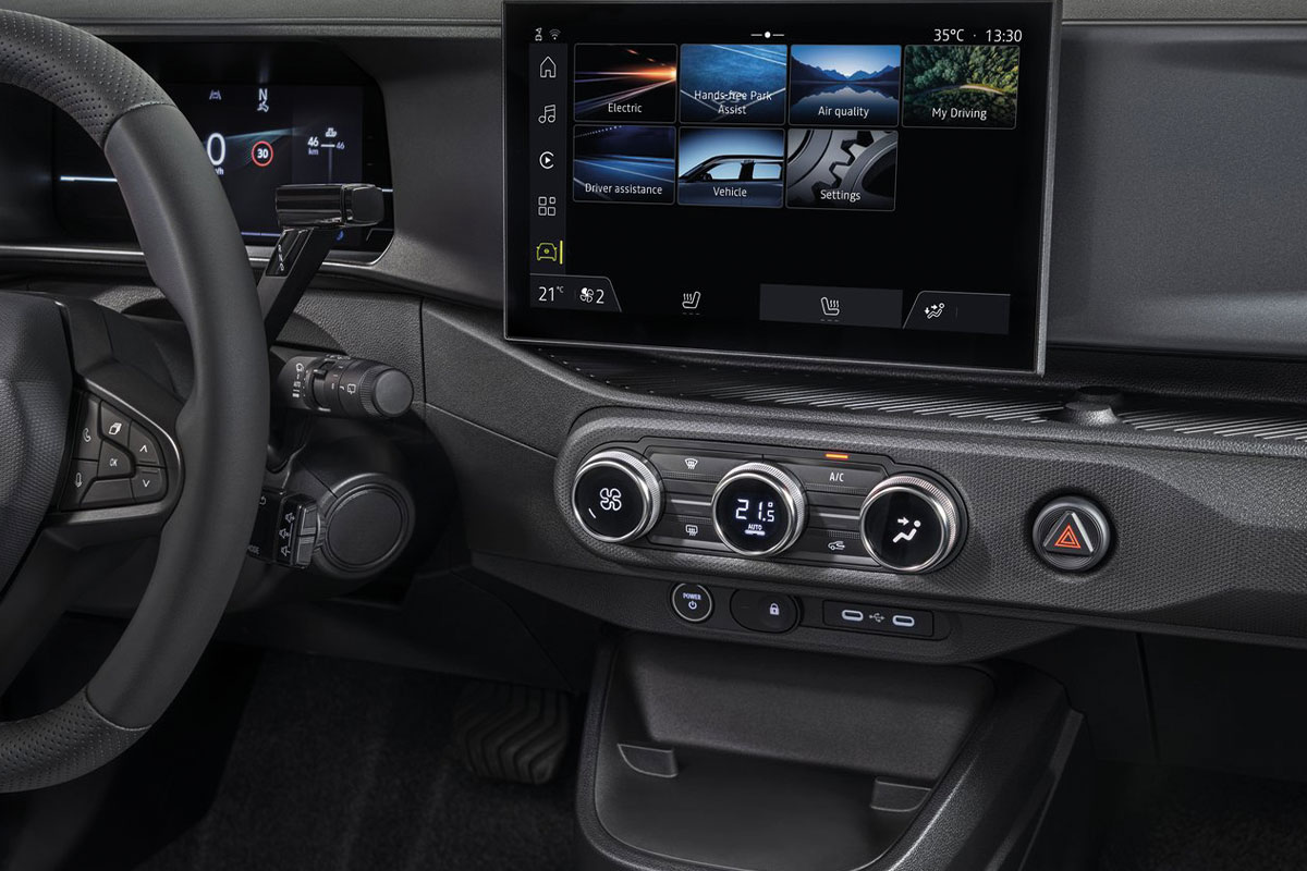Detailansicht des Fahrzeugcockpits mit digitalem Infotainment-Touchscreen, Klimabedienung und digitaler Instrumentenanzeige.