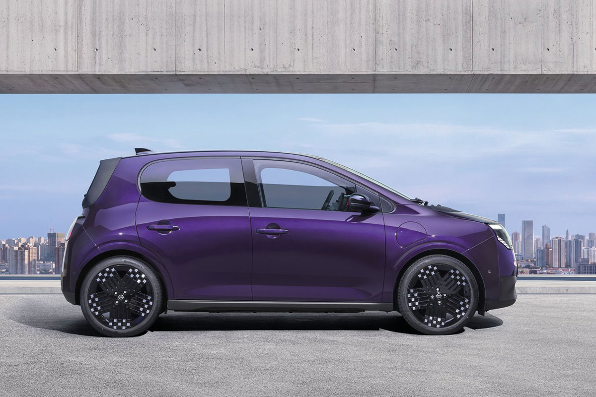 Violetter Nissan Pixo in vollständiger Seitenansicht vor einer modernen Stadtkulisse.