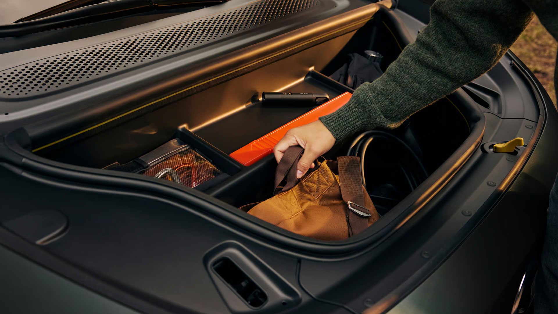 Eine Person stellt eine Tache in den Frunk des Volvo EX60.