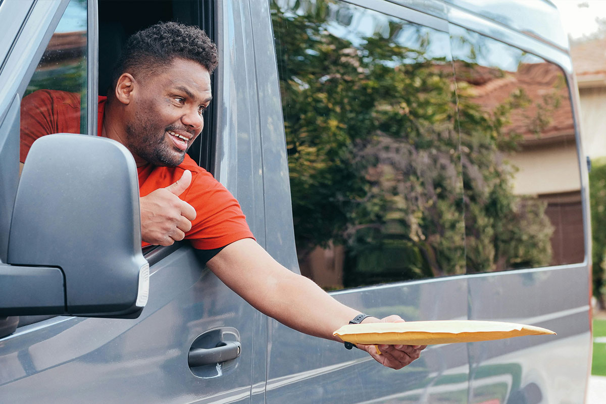 Ein Lieferant, der ein Packet aus dem Auto überreicht